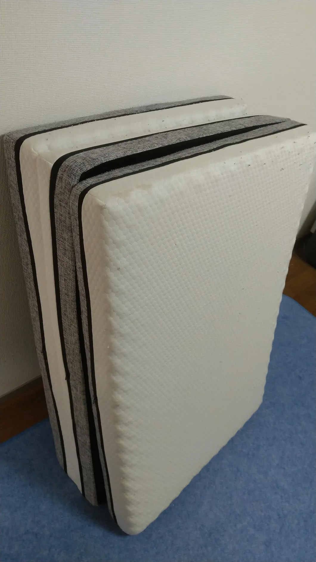 三つ折りにして立てかけた篠原化学エコラテ エリートのマットレス。