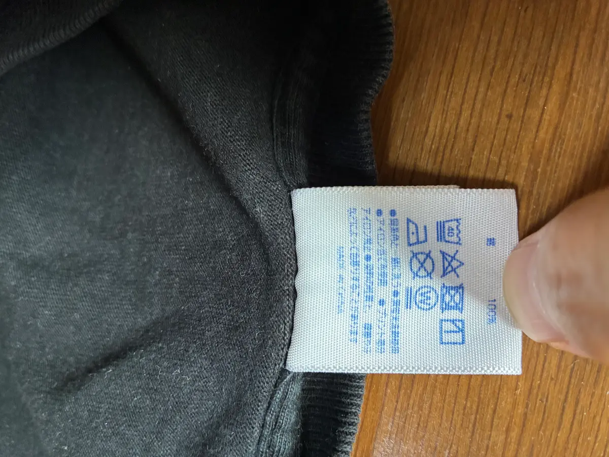 ユナイテッドアスレTシャツの素材と洗濯表示が記載された品質表示タグ。
